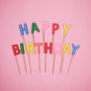 Letter-Shaped Happy Birthday Candles On Pink Background
